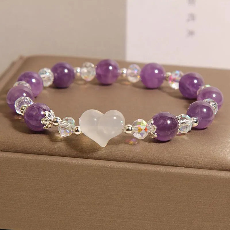 Natural amethyst bracelet with white agate love heart charm on a light background