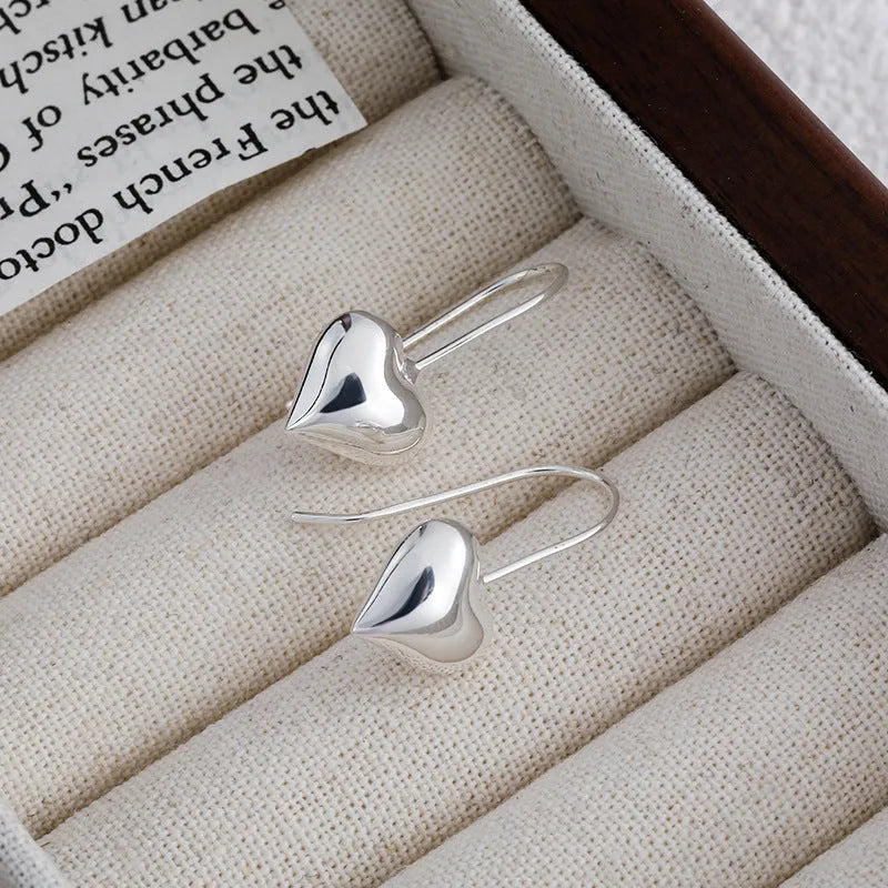 Silver-coloured heart-shaped earrings with three-dimensional glossy finish and Korean-style design