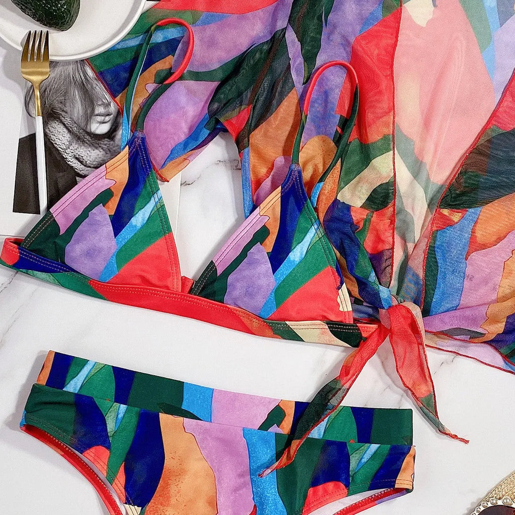 Red women's nylon split swimsuit on a hanger, showing printed design and bikini style.
