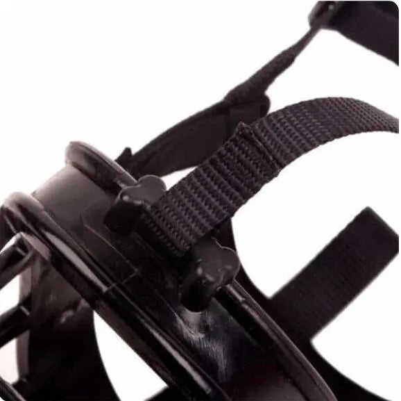 Soft silicone dog muzzle in black with cotton webbing strap on a table, anti-bite and anti-eating design