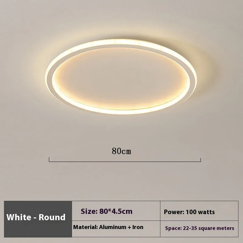 Modern minimalist circular LED ceiling lamp in black finish with integrated lights, shown in a bedroom setting.