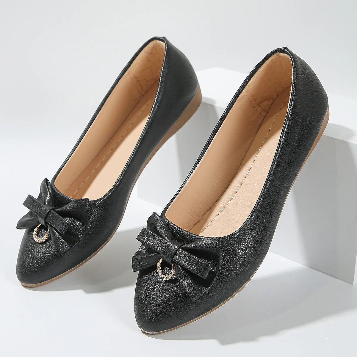 Women's beige flat casual shoes with a bowknot and shallow mouth design on a white background.