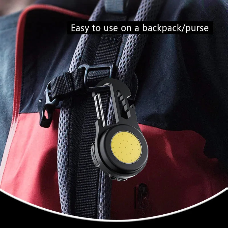 Black 6-in-1 multi-functional mini keychain lamp with COB light and magnetic base on metal surface