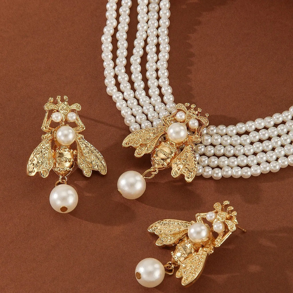 Golden bee earrings and necklace set on display with alloy pendant and regular chain