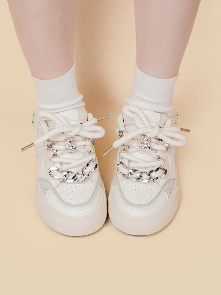 Casual women's white low-top sneakers with rubber sole and lace-up closure on a neutral background