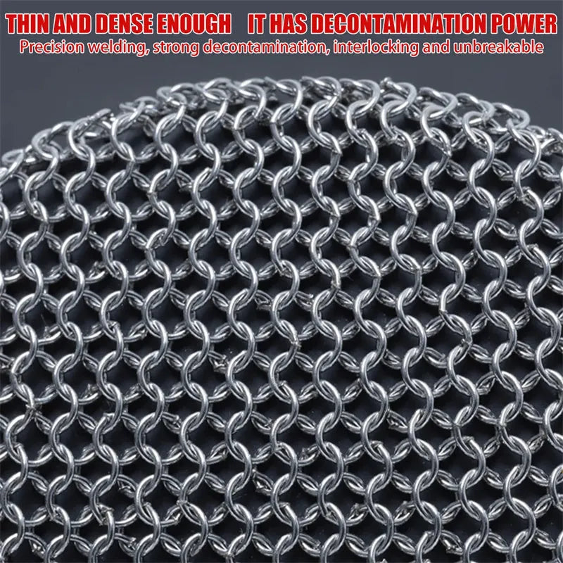 Round 316 stainless steel chainmail scrubber with red silicone handle on cast iron skillet