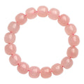 Pink crystal barrel-shaped bead bracelet on a wrist, showing geometric beads and polished finish.