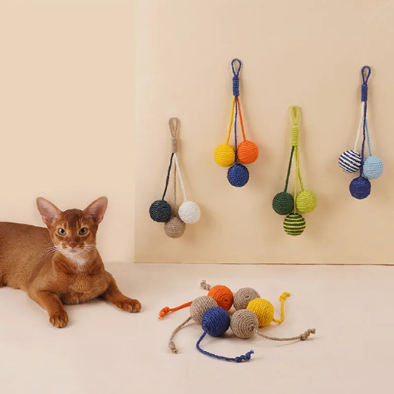 Cat toy set with blue and green teaser stick, red and yellow catnip balls, and a tumbling pet on a white background