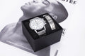 Men's quartz wrist watch set with round alloy dial, black face, and stainless steel buckle on a plain background