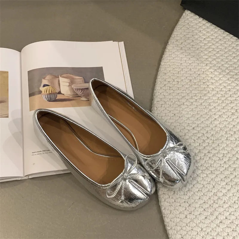 Women's black split-toe flat pumps with a round toe and slip-on oversleeve design.