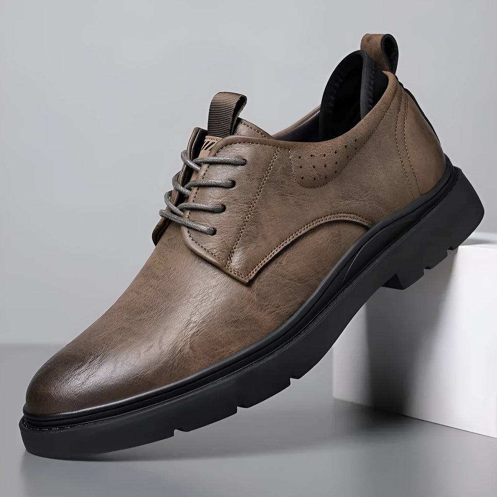 Men's black and brown leather casual sneakers with sewing line detail on the cowhide upper and a rubber sole.