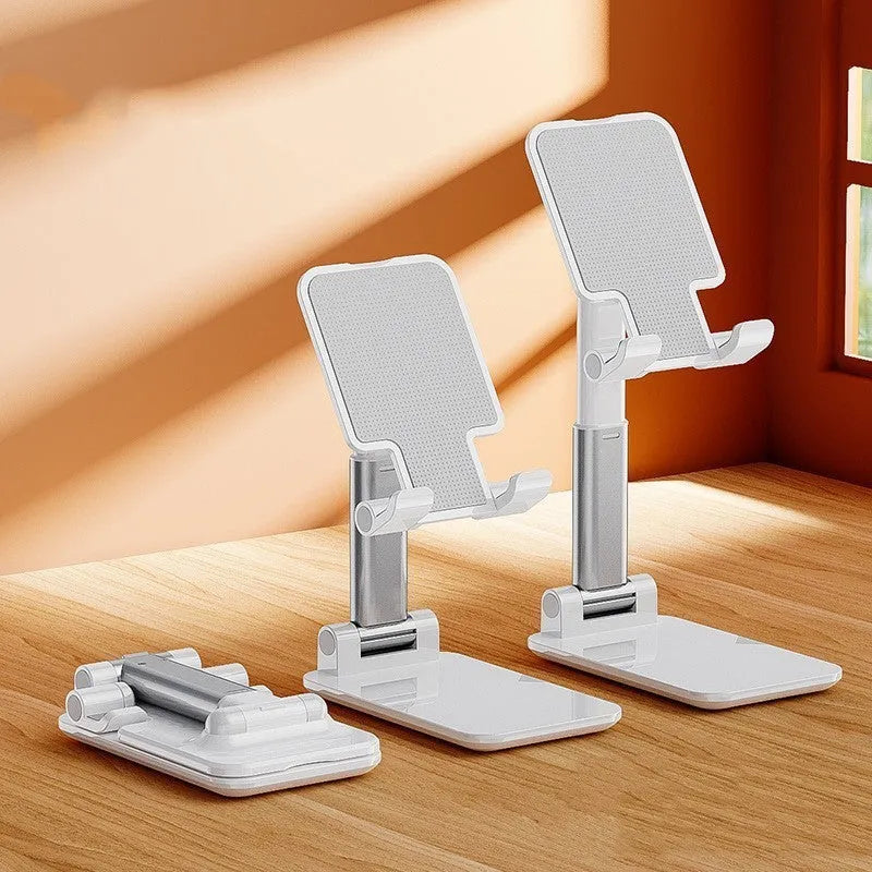 White folding telescopic mobile phone bracket holding a smartphone on a desktop