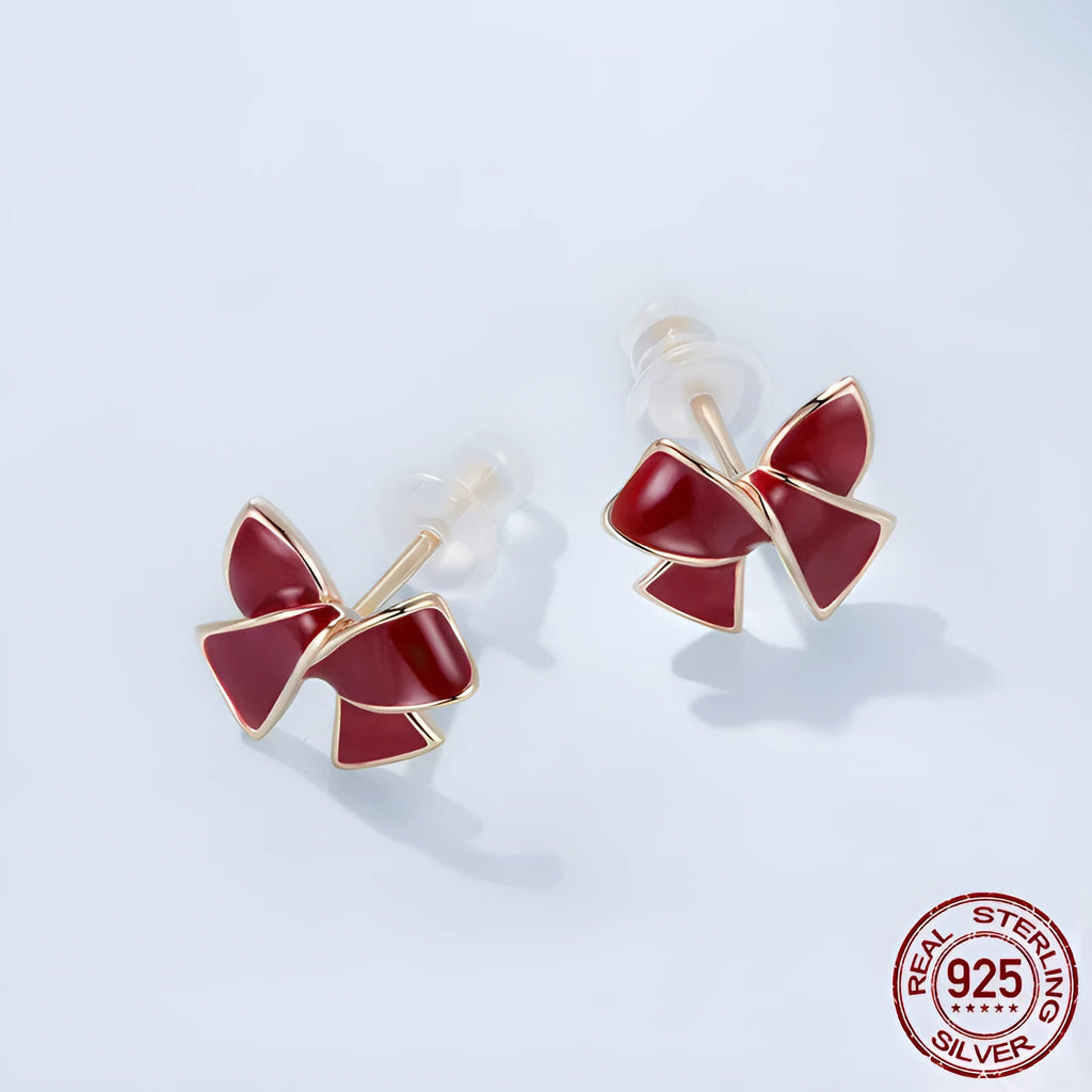 Pair of silver 925 sterling silver bow stud earrings with wine red finish on white background