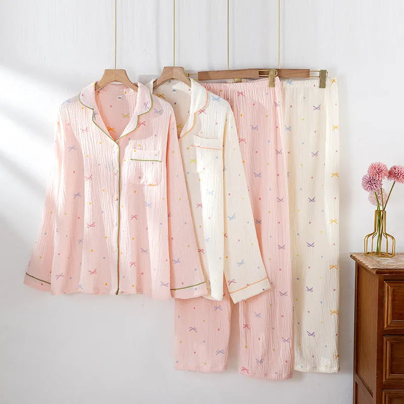 Women's pink cotton long-sleeved pajama top and trousers set laid flat.