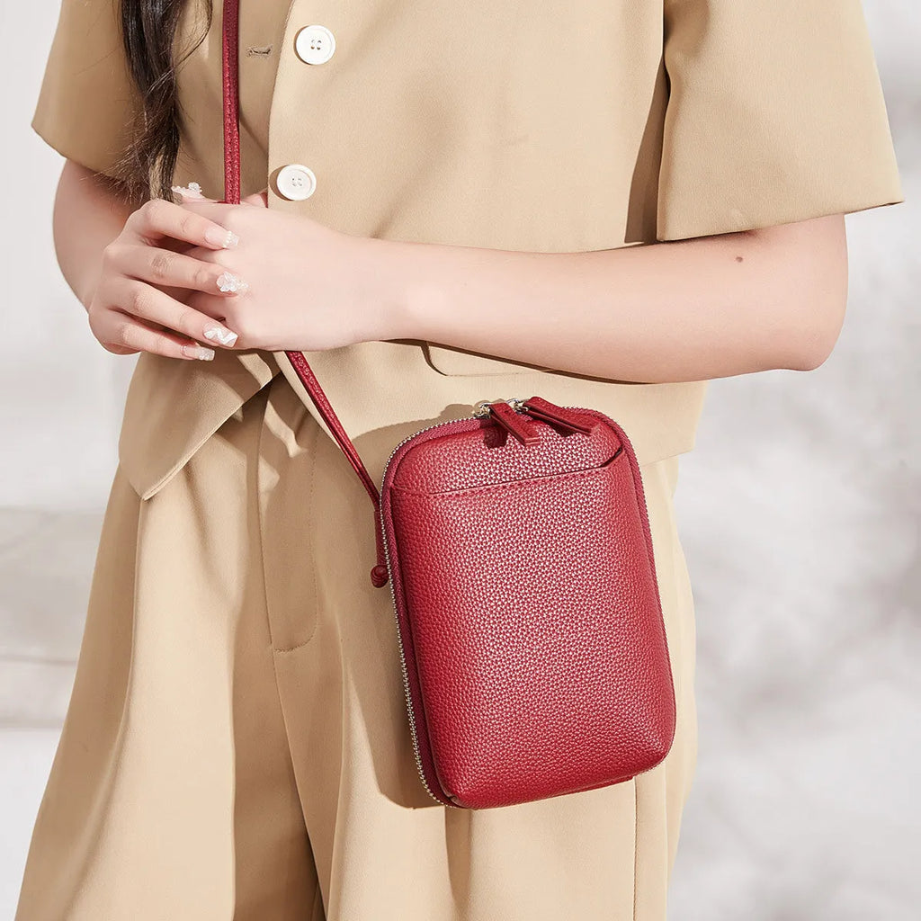 Simple women's vertical crossbody bag in solid colour with stitching details and single strap