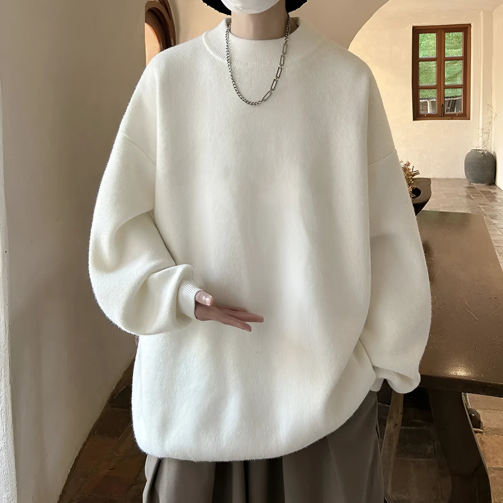 A man's solid colour round neck pullover sweater with long sleeves in a loose, casual fit.