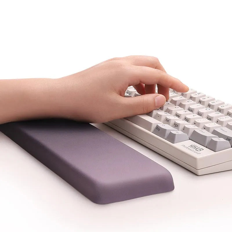 Square black silica gel wrist rest mouse pad with cloth surface on a desk.