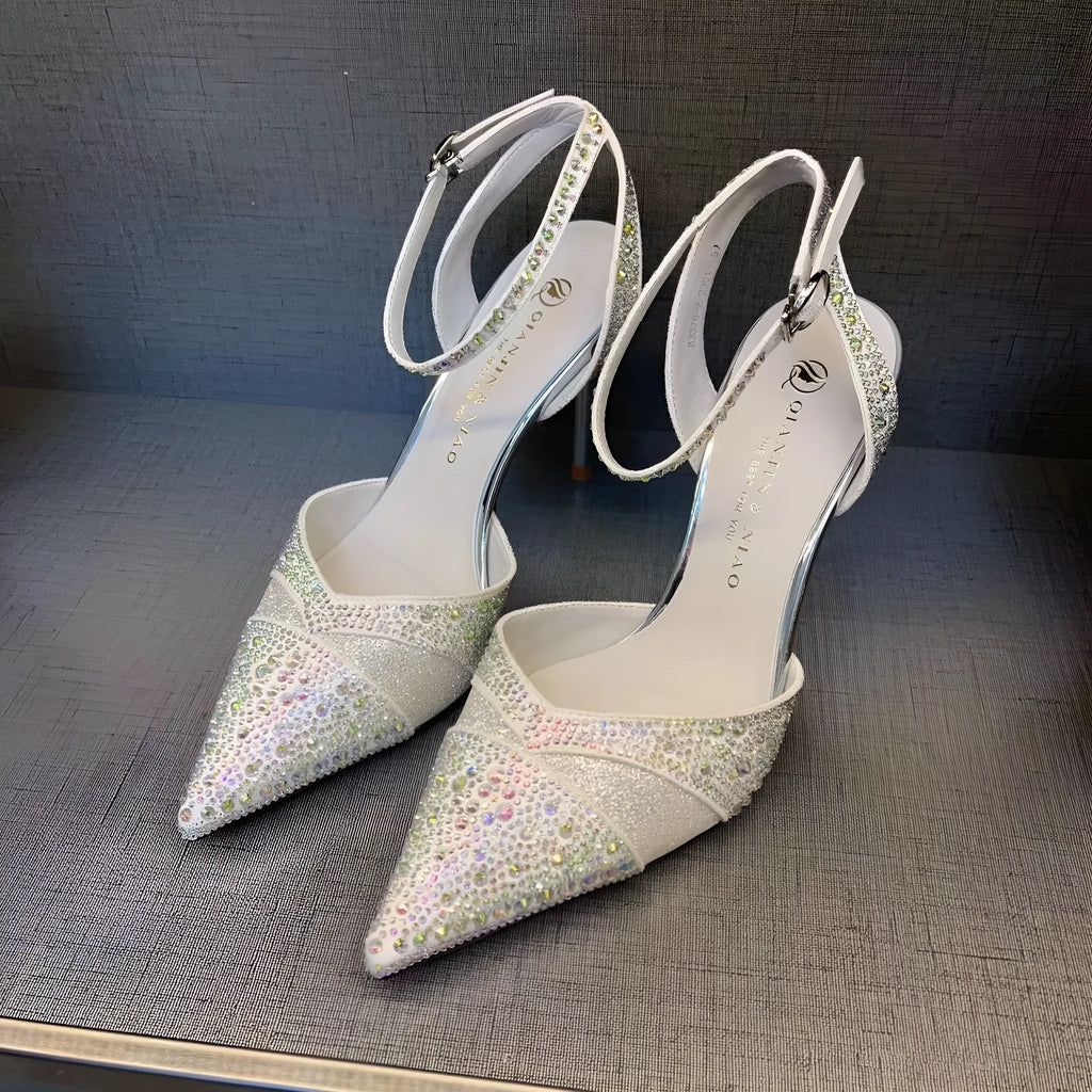 Women's black hollow high heel with stiletto heel, pointed toe, and red sole on a light background.