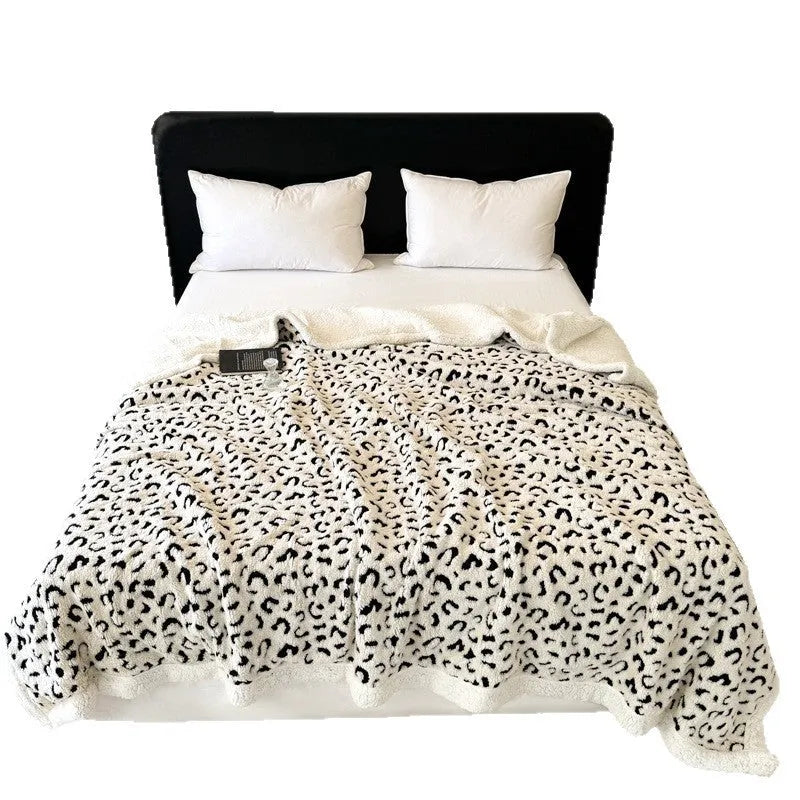 Double-layer jacquard taffeta blanket with leopard print pattern in a camel colour, laid flat on a bed.