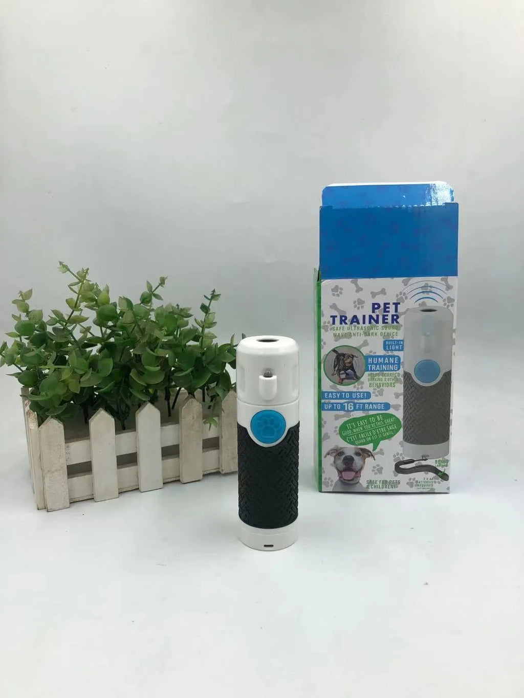 White handheld ultrasonic dog bark control trainer device on a plain background.