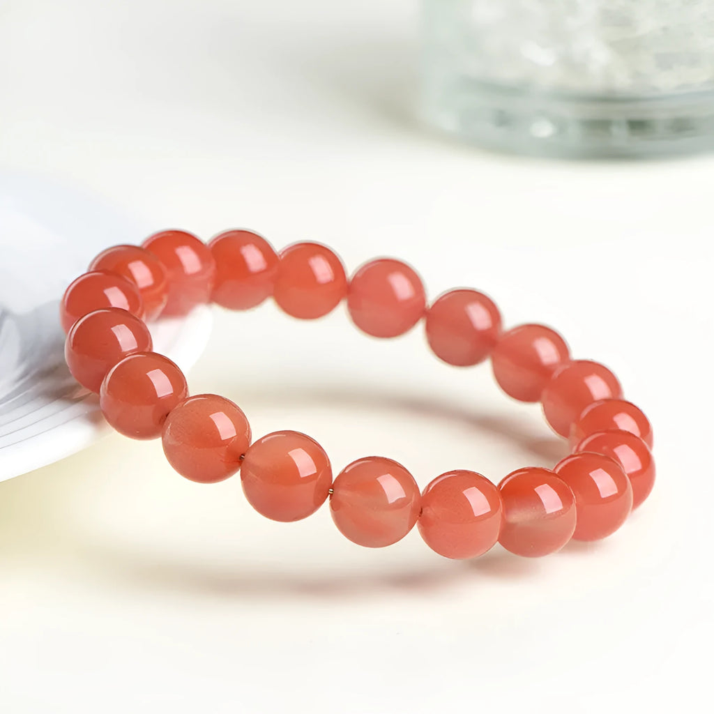 Natural cherry red agate beaded bracelet with polished round stones on a string.