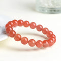 Natural cherry red agate beaded bracelet with polished round stones on a string.