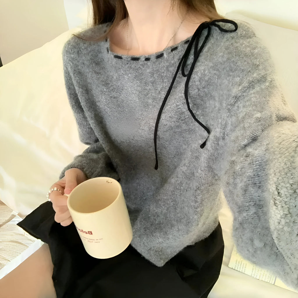 Grey loose-fitting women's pullover sweater made from regenerated cellulose knitwear on a hanger.