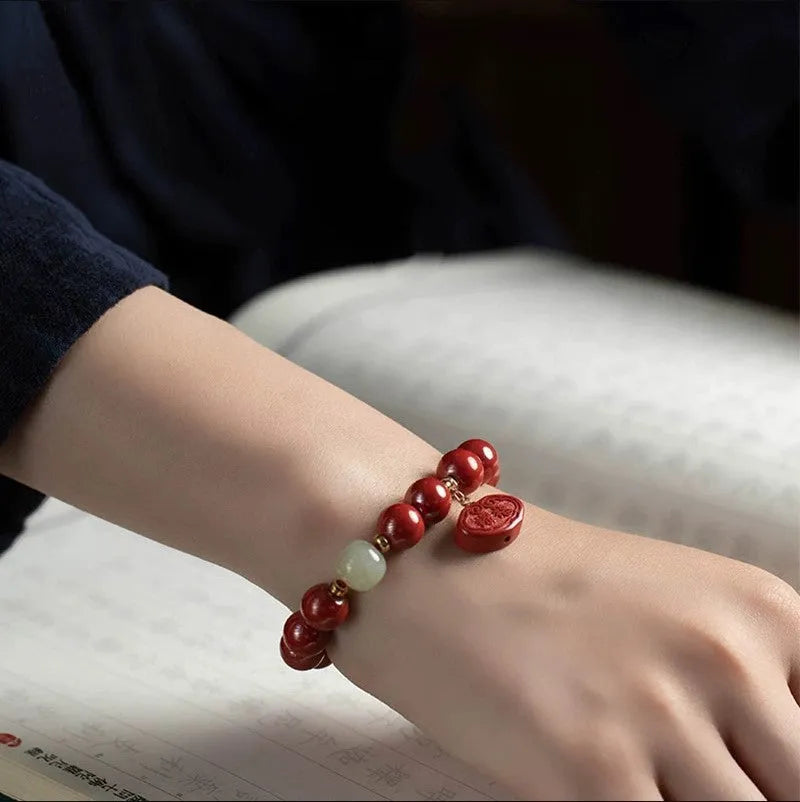 Red cinnabar Emperor Sandstone Ping An Fu Lu adjustable bracelet on wrist.