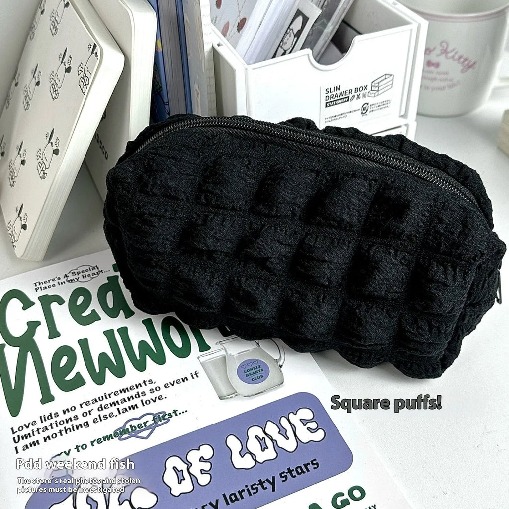 Cream puff style fabric pencil case in beige or black with zip closure