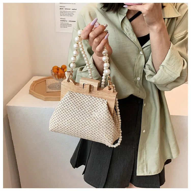Women's straw woven shoulder bag with pearl chain strap and multiple internal compartments in horizontal square shape