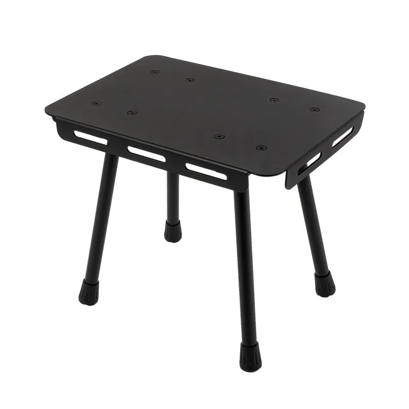 Aluminium folding stool set up as a small table with a beige PU mat cushion, next to its storage bag.