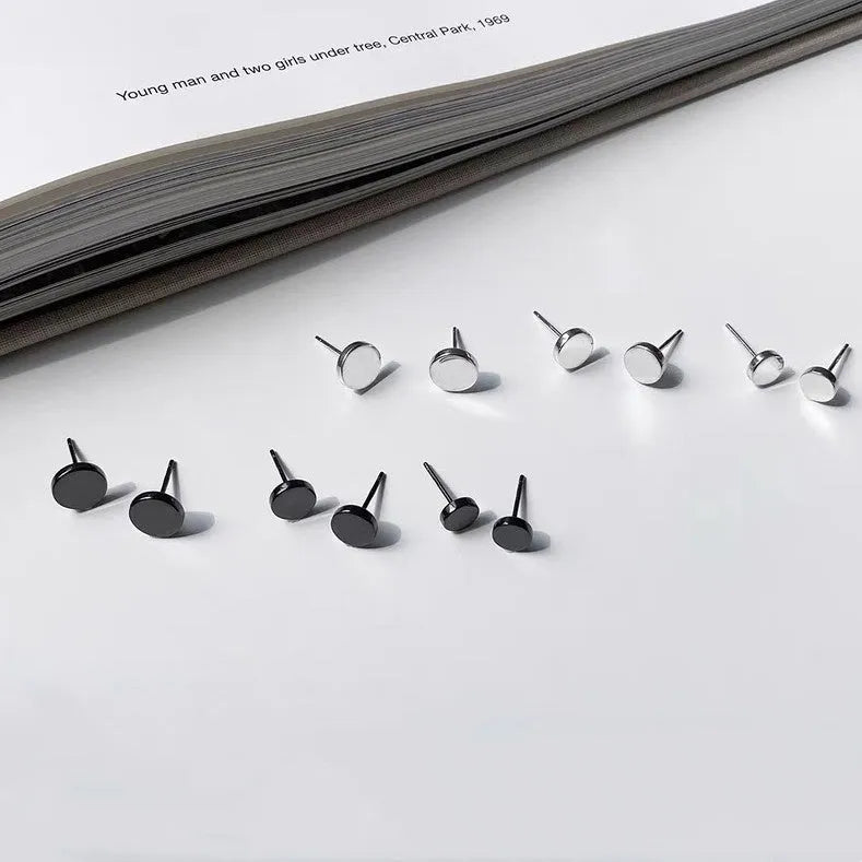 A pair of flat, round sterling silver S999 bone stud earrings on a plain background, showing silver and black colour options.