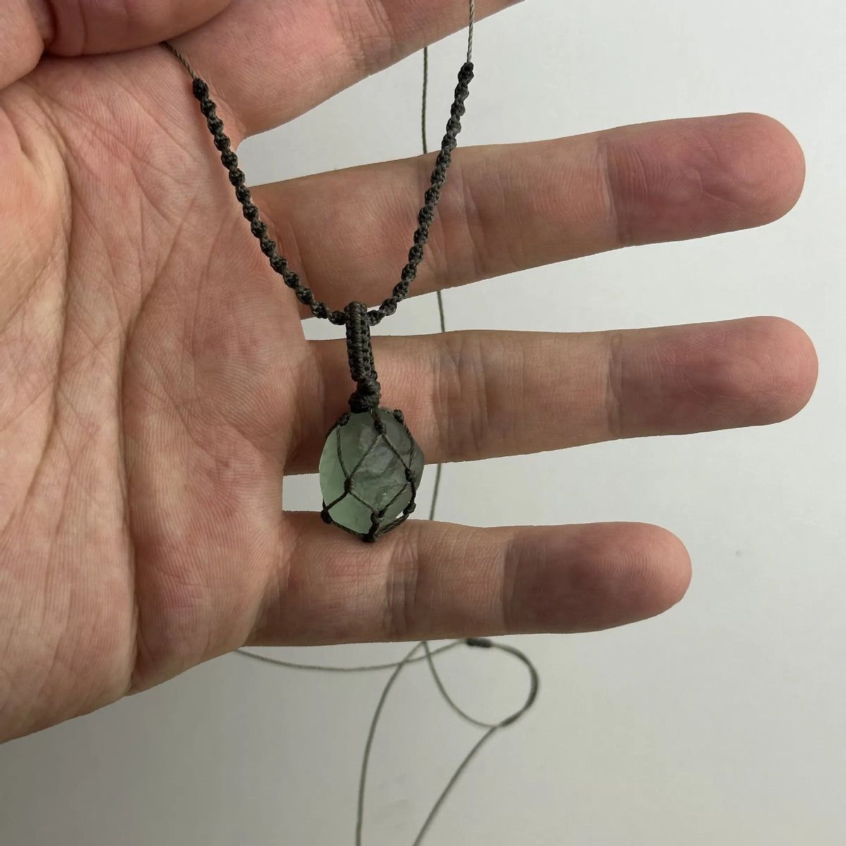 Artificial crystal rough labradorite-style pendant necklace with O-link chain on display