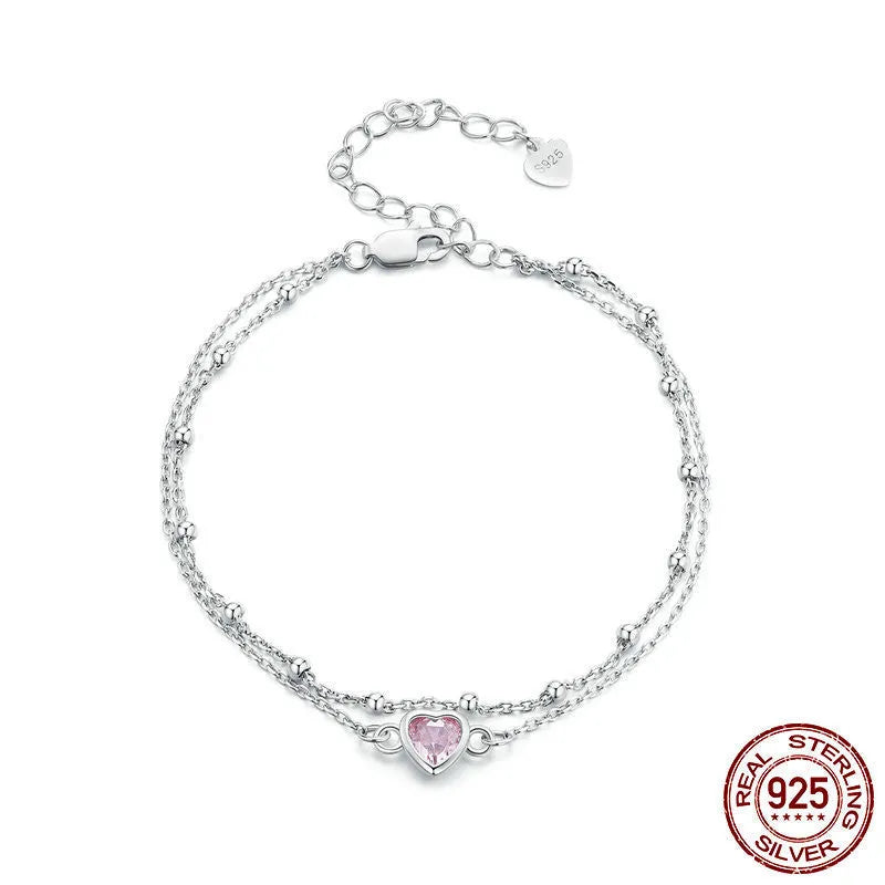 Women's sweet style sterling silver heart bracelet with adjustable chain on white background.