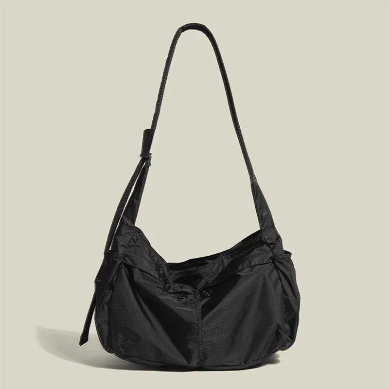Waterproof nylon messenger bag in black colour showing horizontal square shape and shoulder strap