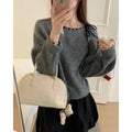 Grey loose-fitting women's pullover sweater made from regenerated cellulose knitwear on a hanger.