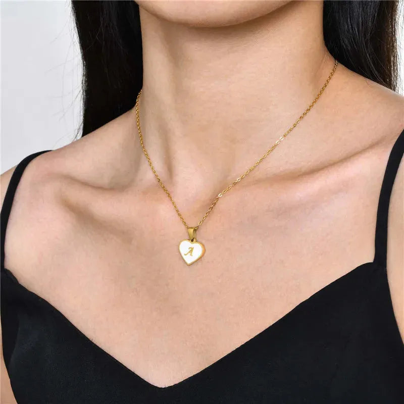 Gold-plated heart necklace with white shell pendant and initial personalisation on a stainless steel chain.