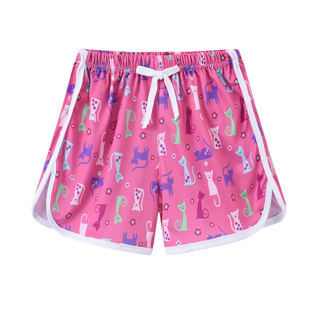 Children's polyester holiday shorts in multiple colours and patterns including stripes, leopard print, and pineapple design.