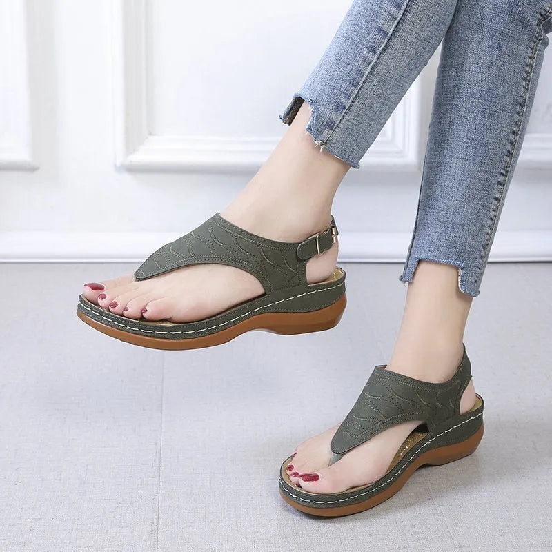 Women's wedge heel sandal in a solid colour with an adjustable back strap buckle.