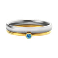 Geometric titanium steel ring with a raised December colour birthstone setting on a gold-toned band.