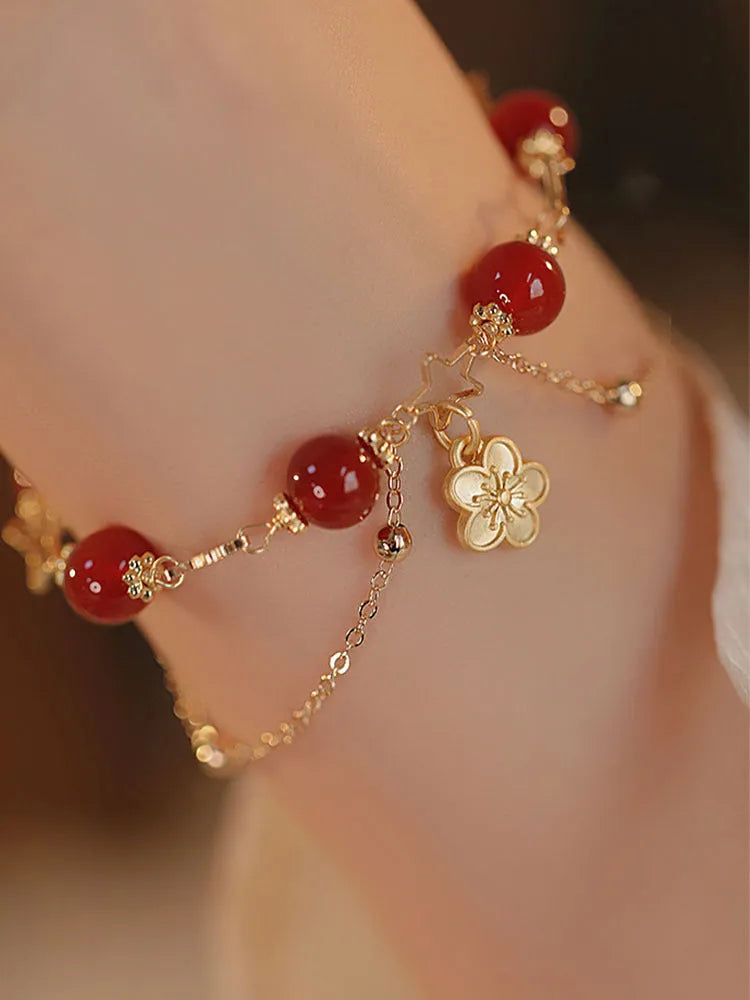 Red agate double layer bracelet with floral and peach blossom design on a wrist