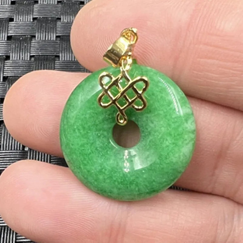 Dry green jade coin buckle pendant 25mm diameter on a light background