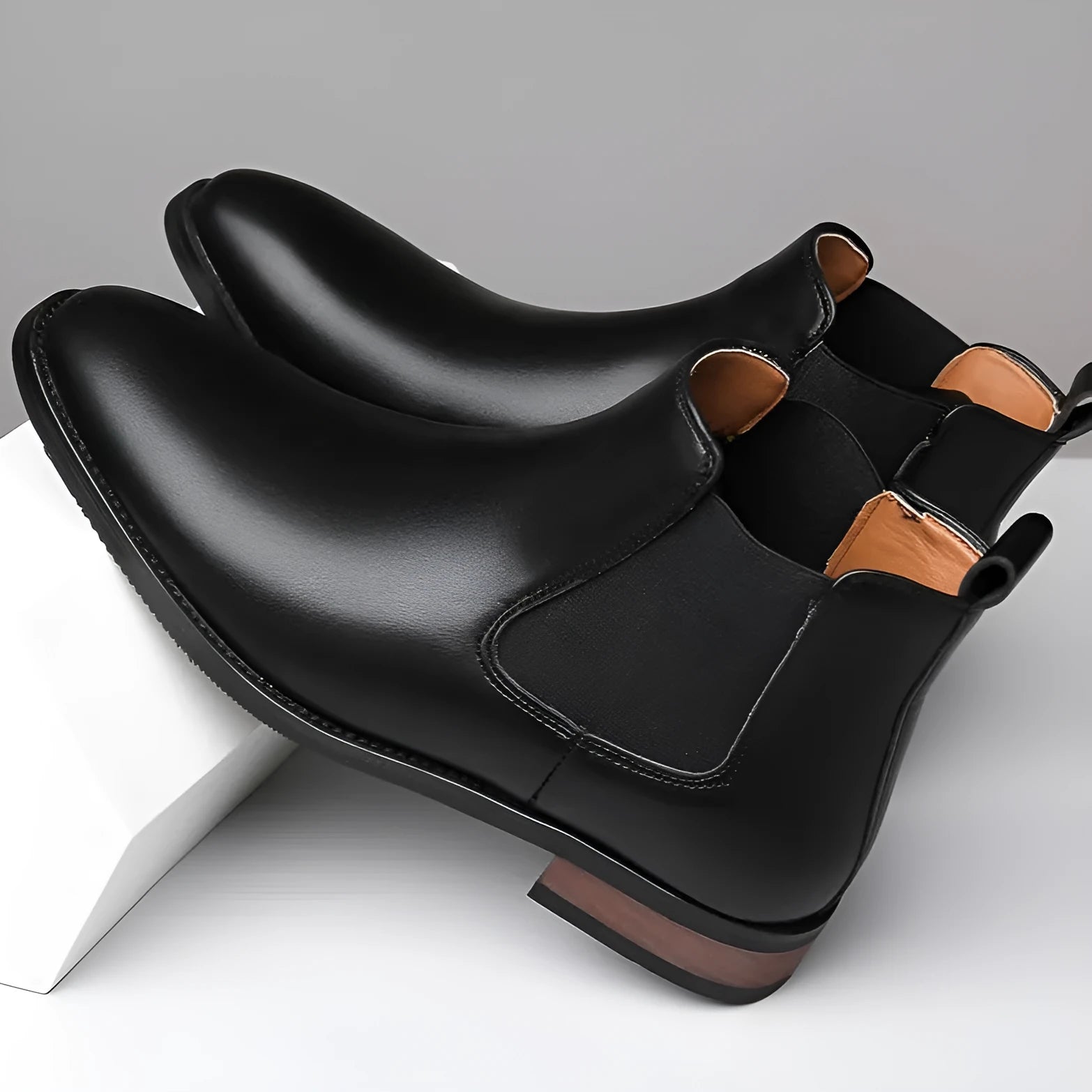 Men's black pointed-toe Chelsea boots with a high-top, mid-calf design and a low rubber sole.
