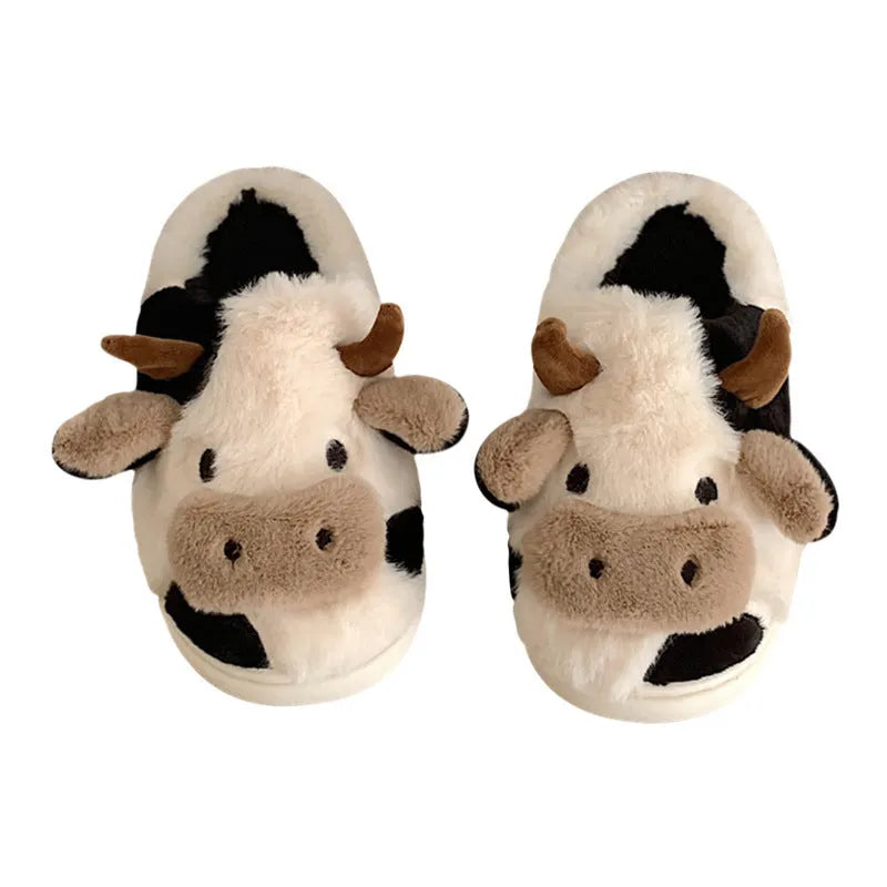 White cartoon cow slippers with plush faux fur and a textured non-slip sole.