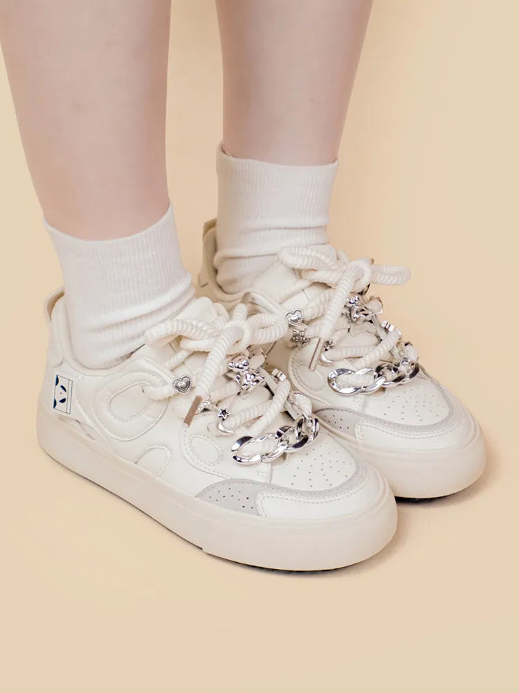 Casual women's white low-top sneakers with rubber sole and lace-up closure on a neutral background