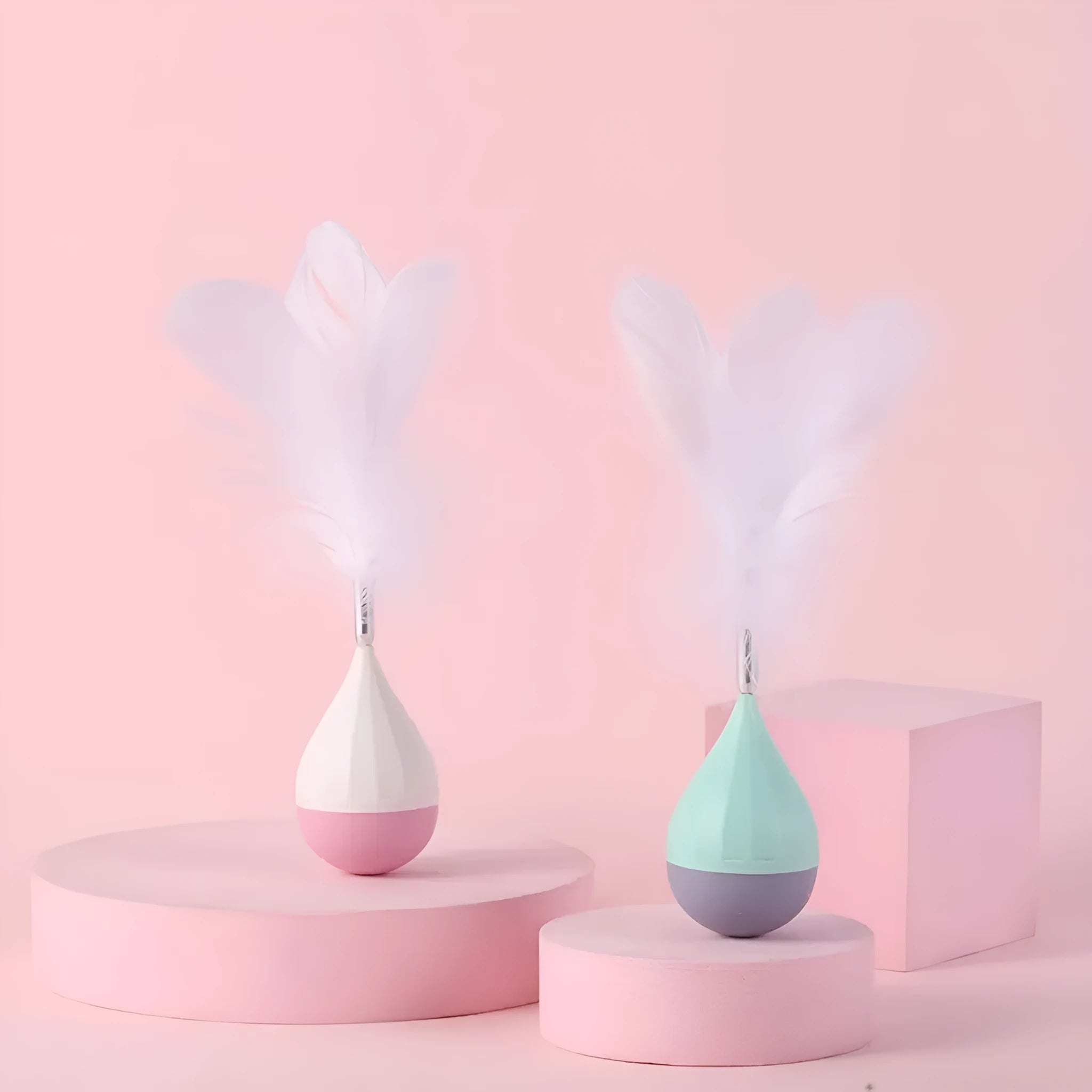 Green feather tumbler cat toy with goose feathers and aluminium alloy components on wooden floor