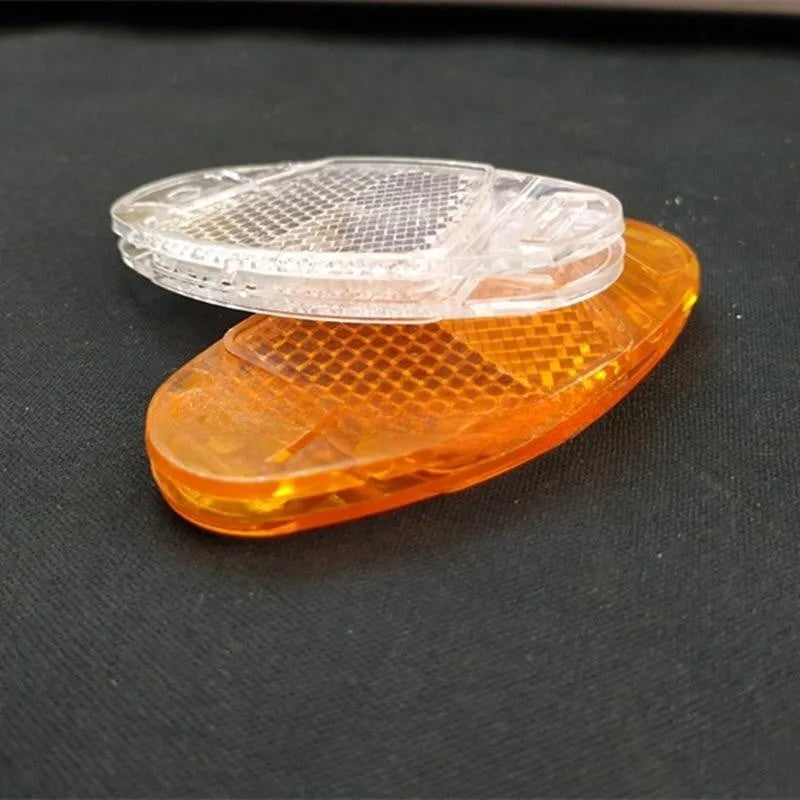 White and yellow plastic bicycle spoke reflectors measuring 7.2cm long by 3.5cm wide for night safety