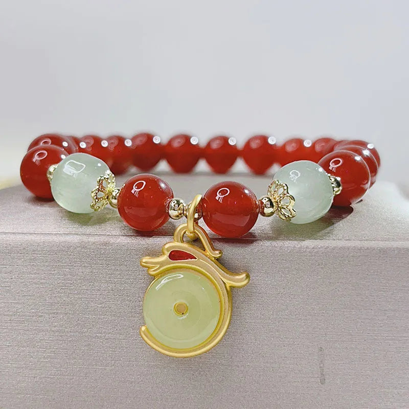 A red agate bracelet for women with a manual crafted dragon design in Chinese style.
